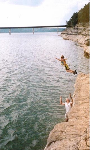 Boy jumping off cliff at norfork lake